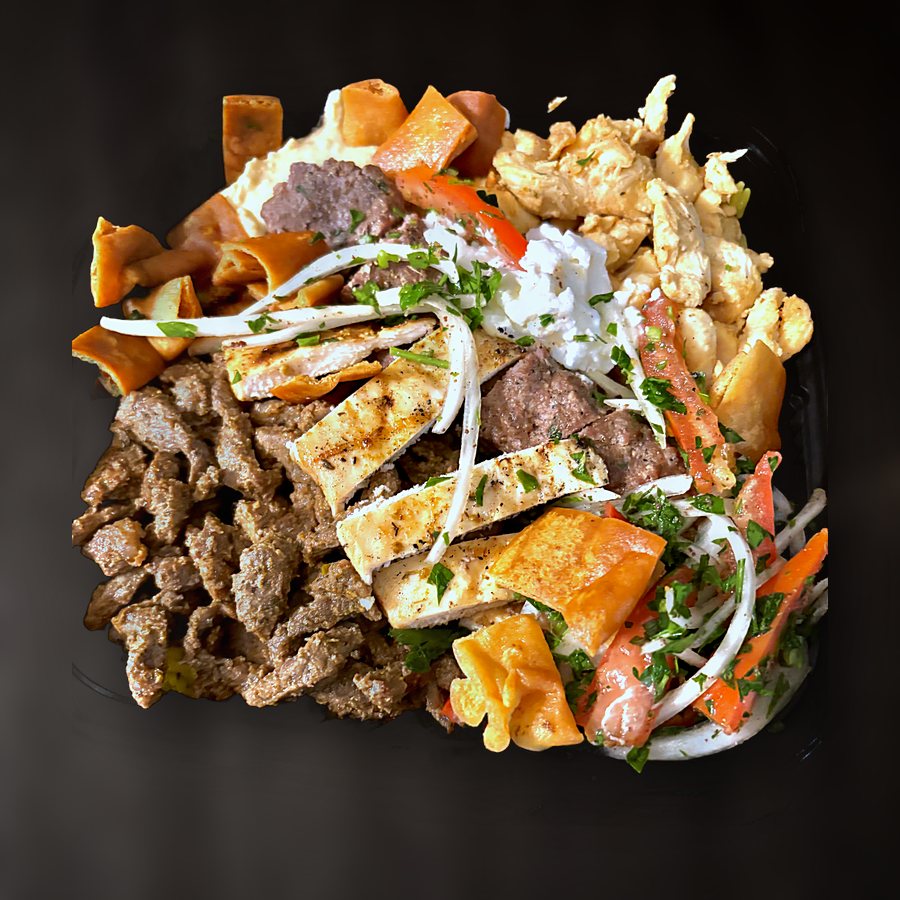 A tray of chicken shawarma, beef shawarma and beef kebab with hummus and salad