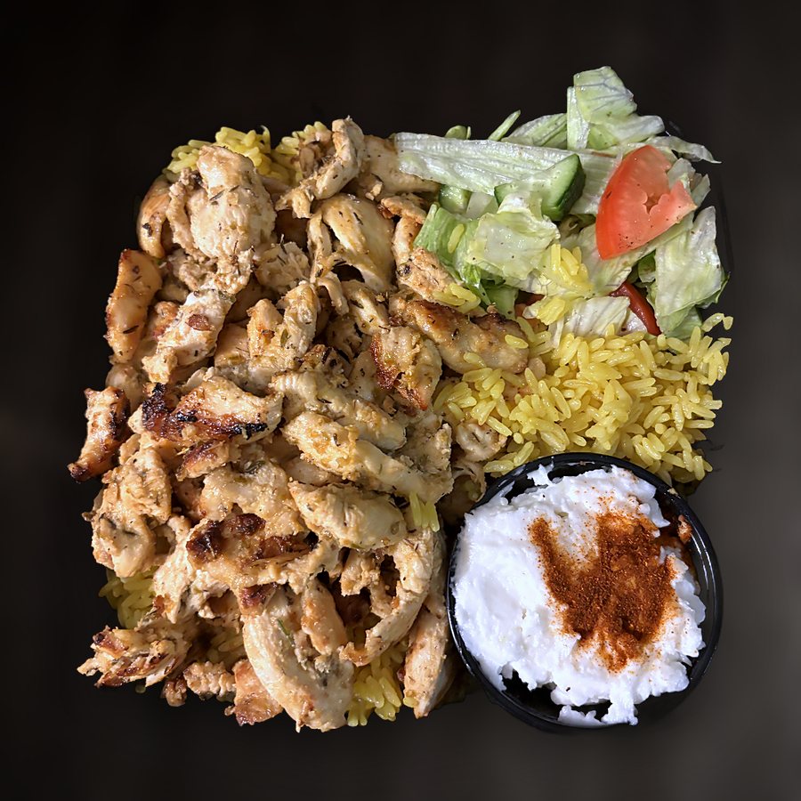 Chicken shawarma over yellow rice with salad and garlic sauce